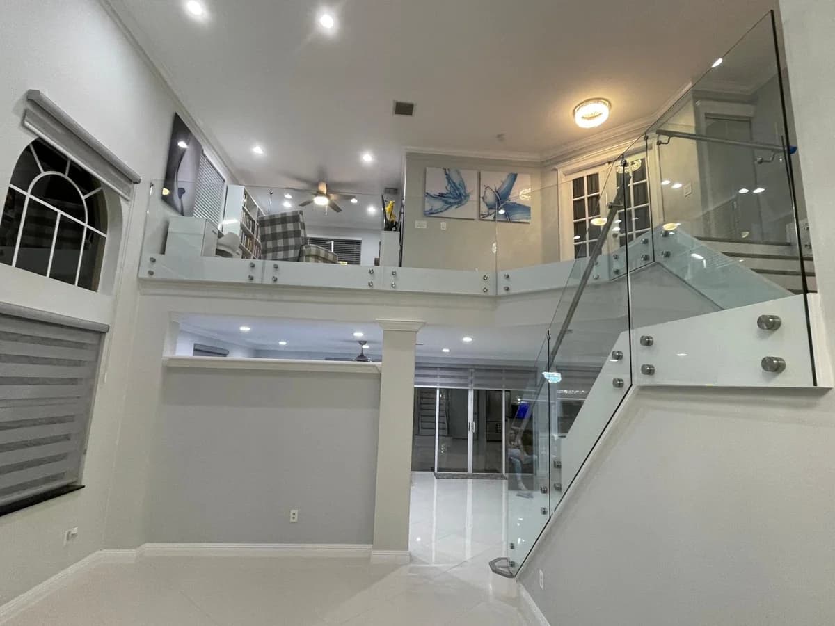 Glass mezzanine and staircase railing installed by Eastern Glass Corp in a South Florida home