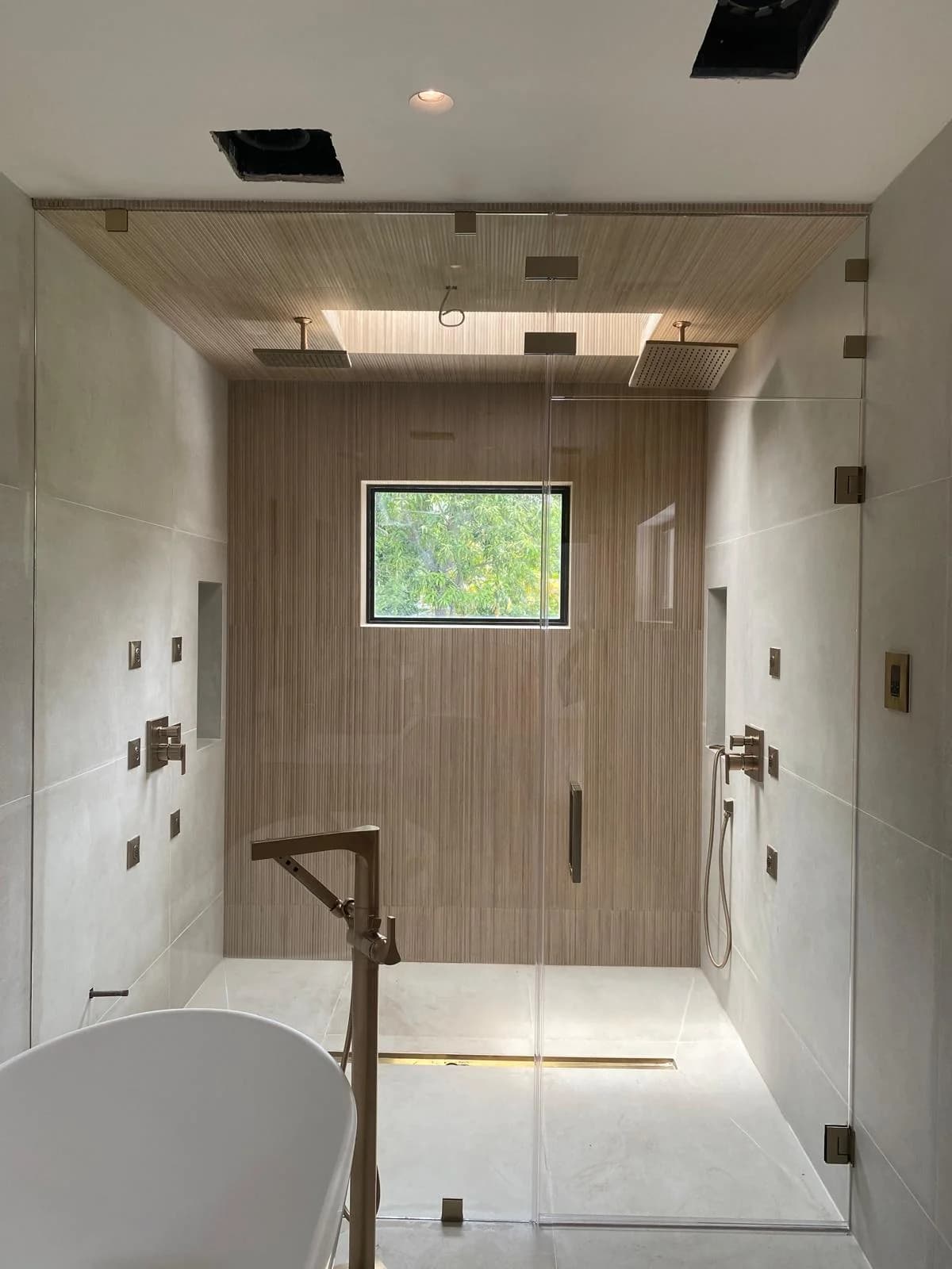 Walk-in shower with ultra-clear low-iron glass panels showing white tile without a green tint
