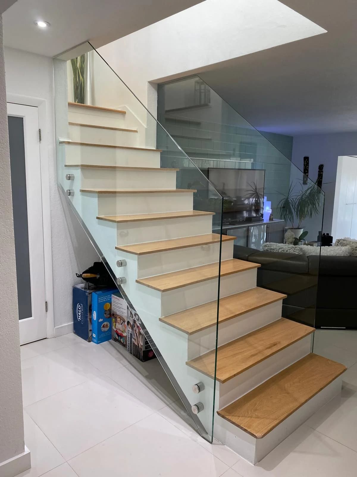 Glass staircase guard with stainless clamps on a floating wood staircase