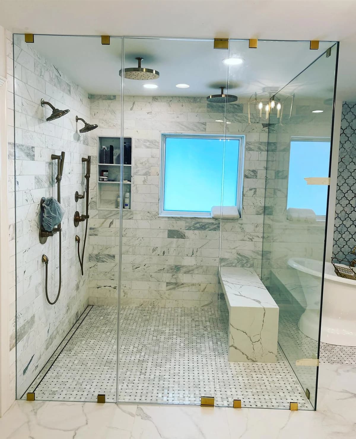 Walk-in frameless glass shower with clamps and fixed panels in a Miami bathroom
